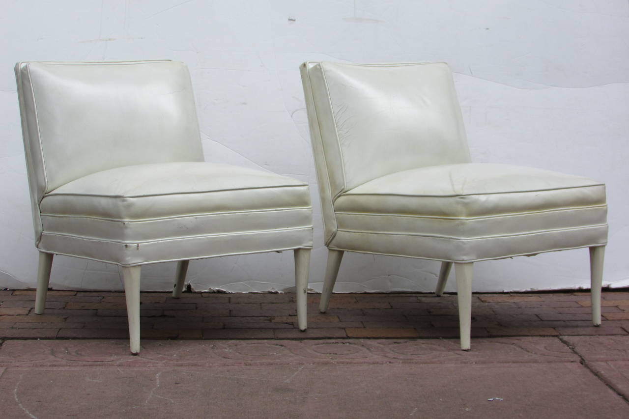 A very beautiful pair of large slipper type lounge chairs in all original pearlized white leather with perfectly tapered white lacquered wood legs -  attributed to Tommi Parzinger - circa 1940 - 1950. Beautiful chairs.