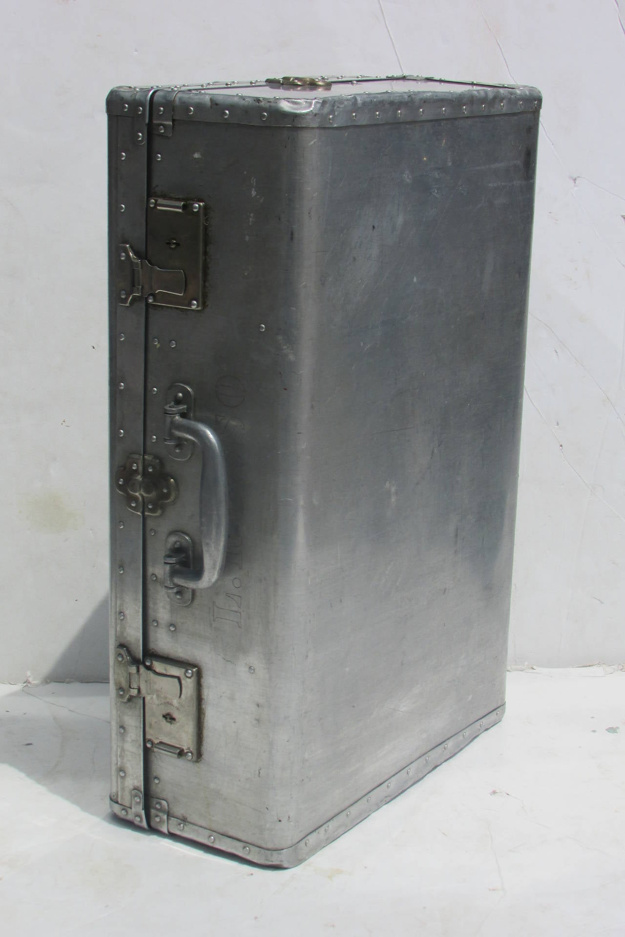 An industrial machine age aluminum riveted suitcase with the components constructed of finely machined aluminum ( aluminum swing handle / aluminum plates surrounding the locking mechanisms are signed King of Kings Key. The interior fitted in the