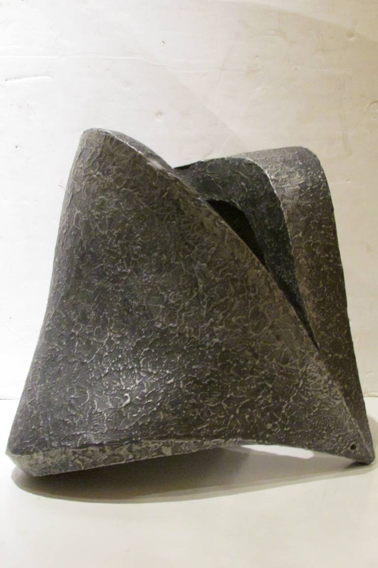 In the style of Jean Arp, a mid-20th century large scale bold abstract solid plaster sculpture with original gun metal black and silvered textured molten lava like surface. No apparent signature.