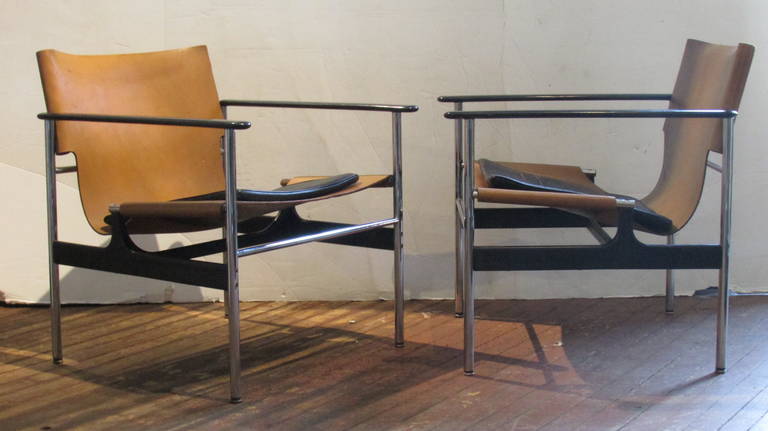 A pair of Charles Pollock sling chairs model 657 for Knoll in cognac leather with black seat pads. Desirable all original condition, structurally perfect, the leather with beautifully aged color.