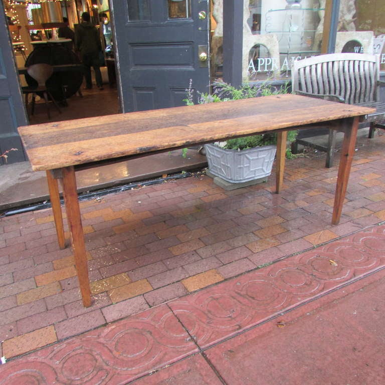 Antique American six foot long folding grange harvest farm table - wide three board top with original old rivets at four corners - all over beautifully aged variegated color / patina and wear from years of use. Tapered square legs secured by metal