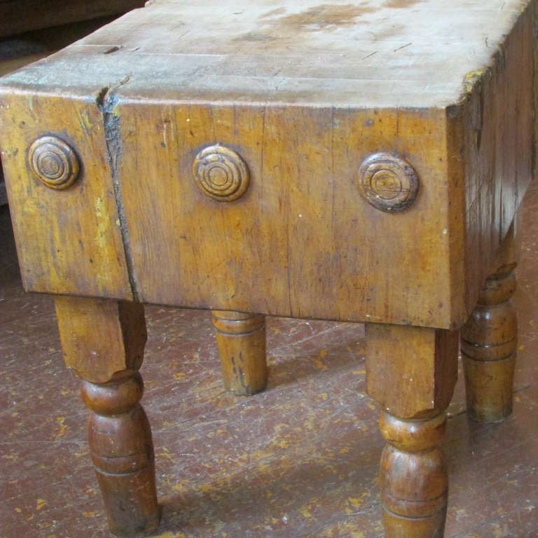Antique 19th century butcher block table - the 24 inch square block is 1 foot thick - it is decorated with raised roundels on one side and exposed inset large iron bolts on opposite side - all raised on chunky turned wood legs - beautiful original