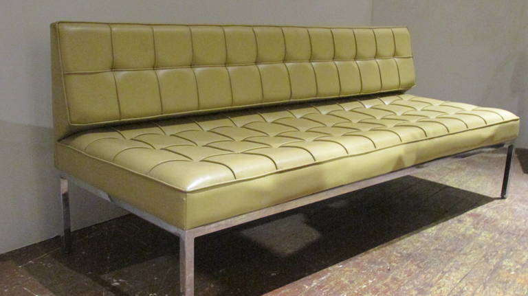 A Florence Knoll for Knoll International six foot armless sofa with a four-legged chromed steel frame and the original beautiful pale mustard color tufted vinyl upholstery. Liquidated many years ago during the remodeling of the executive offices of