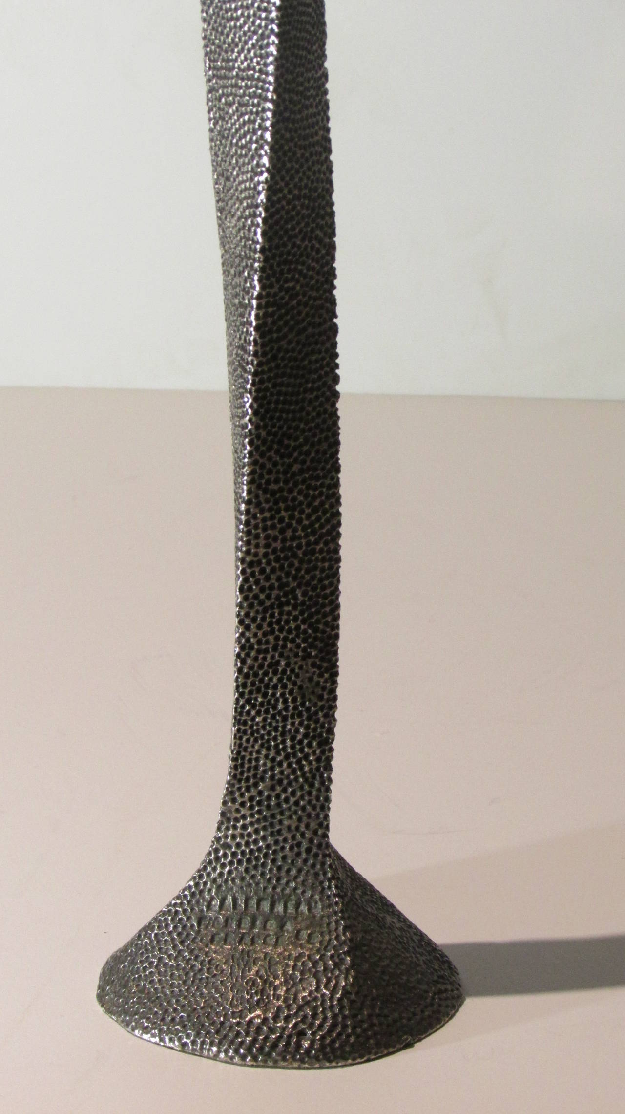 A gun silver finish metal candlestick with an exotic sinuous tall form and a very finely detailed shagreen stingray skin like textured surface by Stephane Galerneau for Fondica, France, 1995. Stamped signed into metal at lower base.