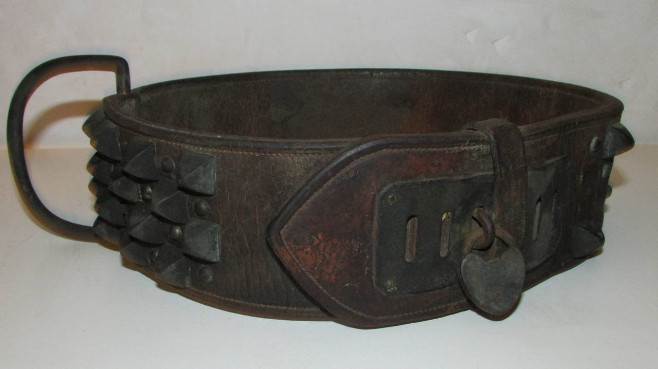 A great looking American antique heavy stitched leather and metal studded spiked dog collar with the original heart-shaped lock and an engraved worn silver metal plate with name of dog, owner and city. Taffy - W. D. Fox - Penn Yan, NY. This collar