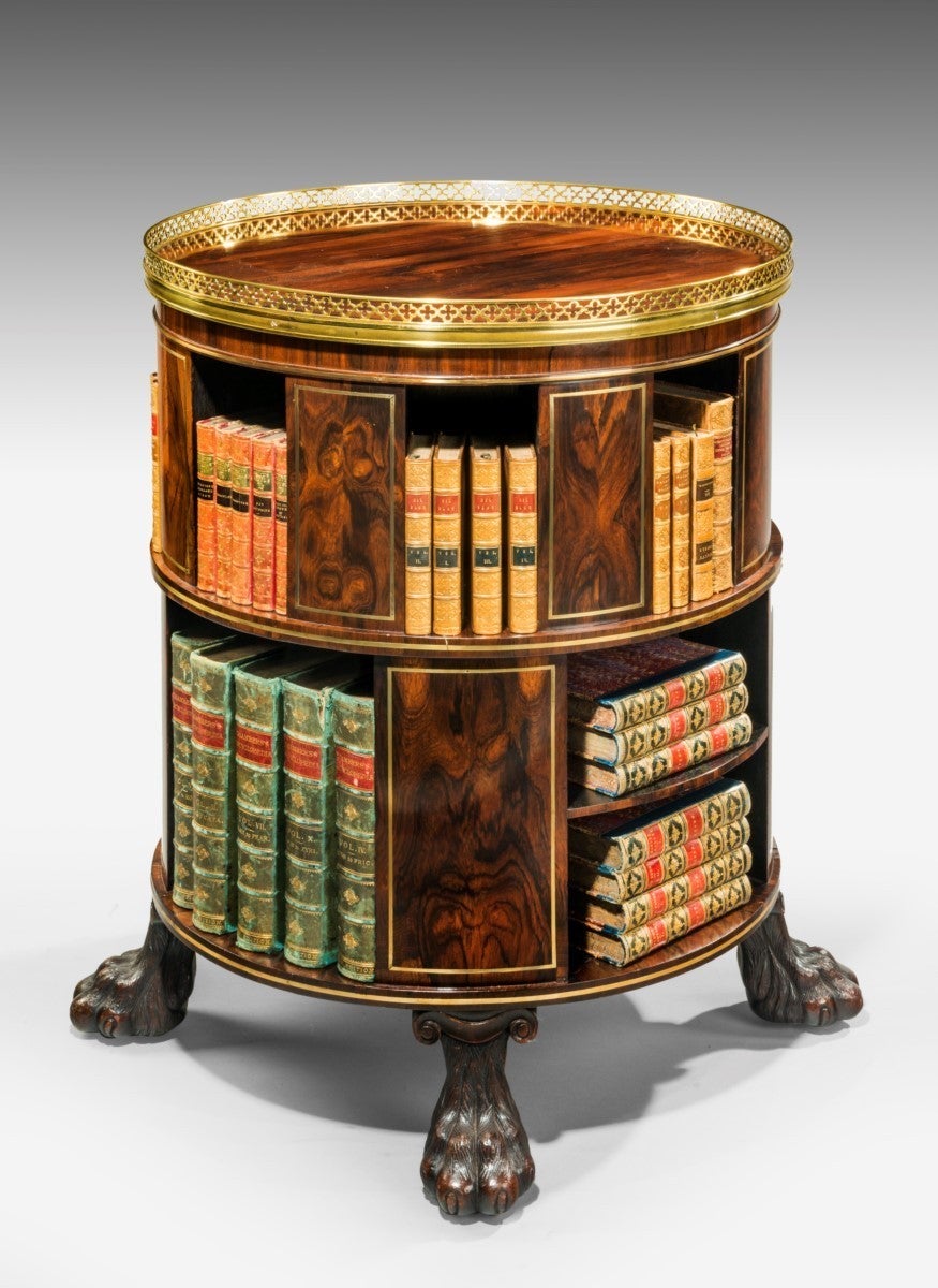 A very rare and unusual freestanding circular rosewood bookcase inlaid throughout in brass. Note the fine quality cast brass lemon-gilt brass lacquered gallery in the Gothic design and the wonderful carved wood lion paw feet on concealed castors.
A