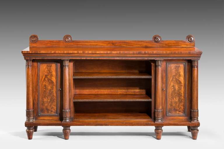 A good quality 19th century mahogany side cabinet. The centre section has two adjustable shelves, the flamed veneered cupboard doors are flanked with turned columns with carved capitals. The whole is raised on six little turned carved feet.