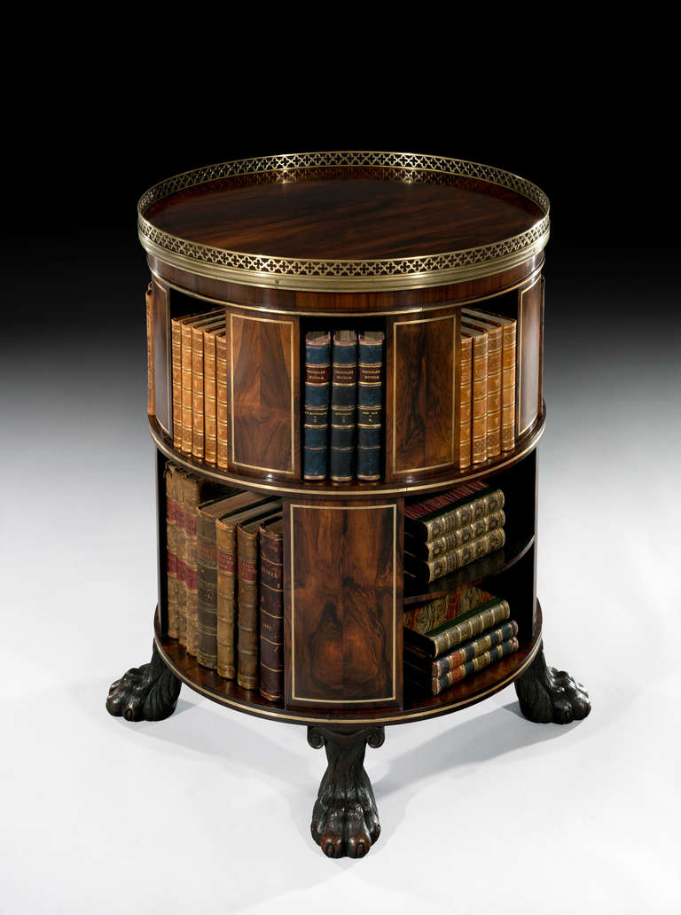 A very rare freestanding circular rosewood bookcase inlaid throughout in brass. Note the gallery in the Gothic design and the wonderful carved wood lion paw feet on concealed castors.

Literature: A similar article is shown in the Regency