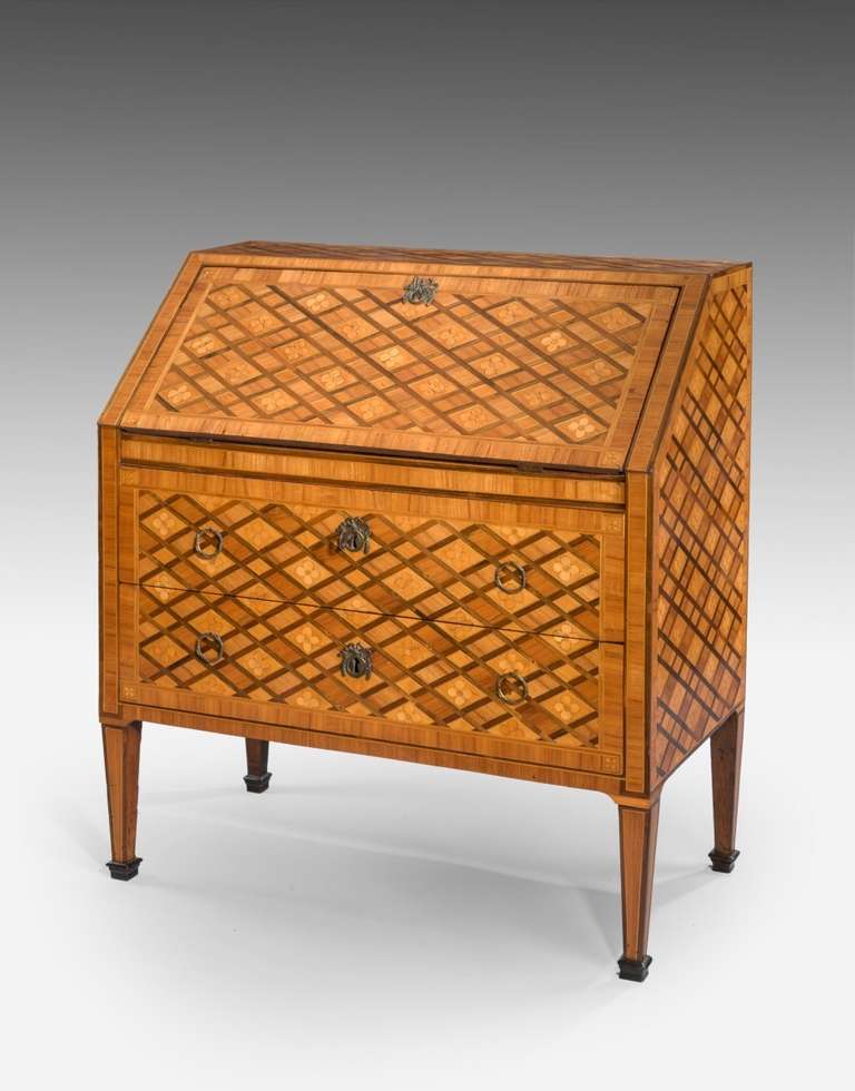 Two drawer writing desk, raised on four square tapering legs, the fall front contains a leather lined writing surface, fully fitted interior of drawers. The whole is tulipwood ground and amaranth with marquetry rosette's and trellis