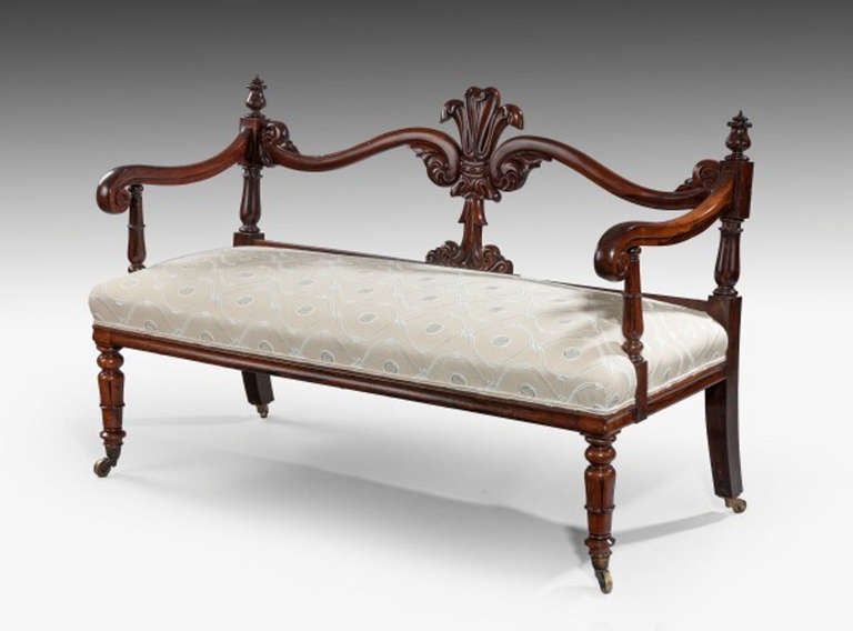 19th century. Good quality solid rosewood hall seat, with arms. Raised on carved turned front legs which are supported on brass castors. Prince of Wales design plume on the back. English circa 1835.