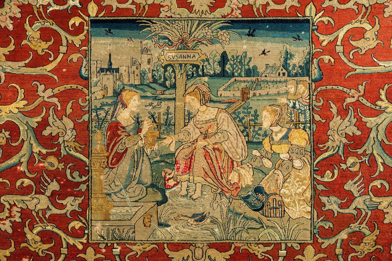 A large rectangular embroidery panel of grotesque design. A depiction from the Old Testament; Susanna with her loyal servants. In the back ground the two old judges spying on her while in the vicinity of her large family house. 
Lowlands Dutch