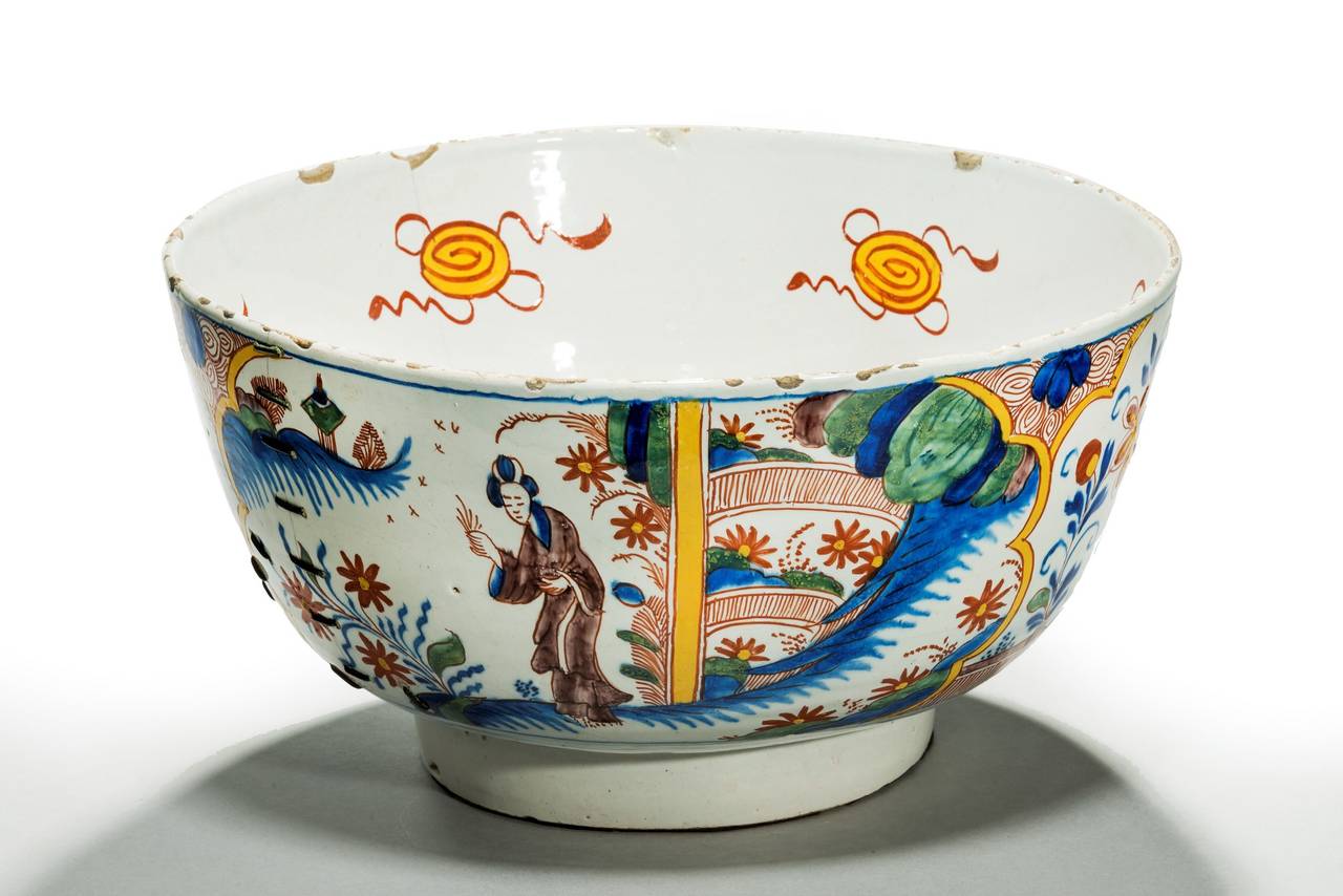 A large and very rare mid 18th century Bristol pottery punch bowl decorated in the chinoiserie style. A single Chinese figure in a garden with fine polychrome colours, reds, greens, yellows and blues. A/F old repairs; chips on the rim, hairline