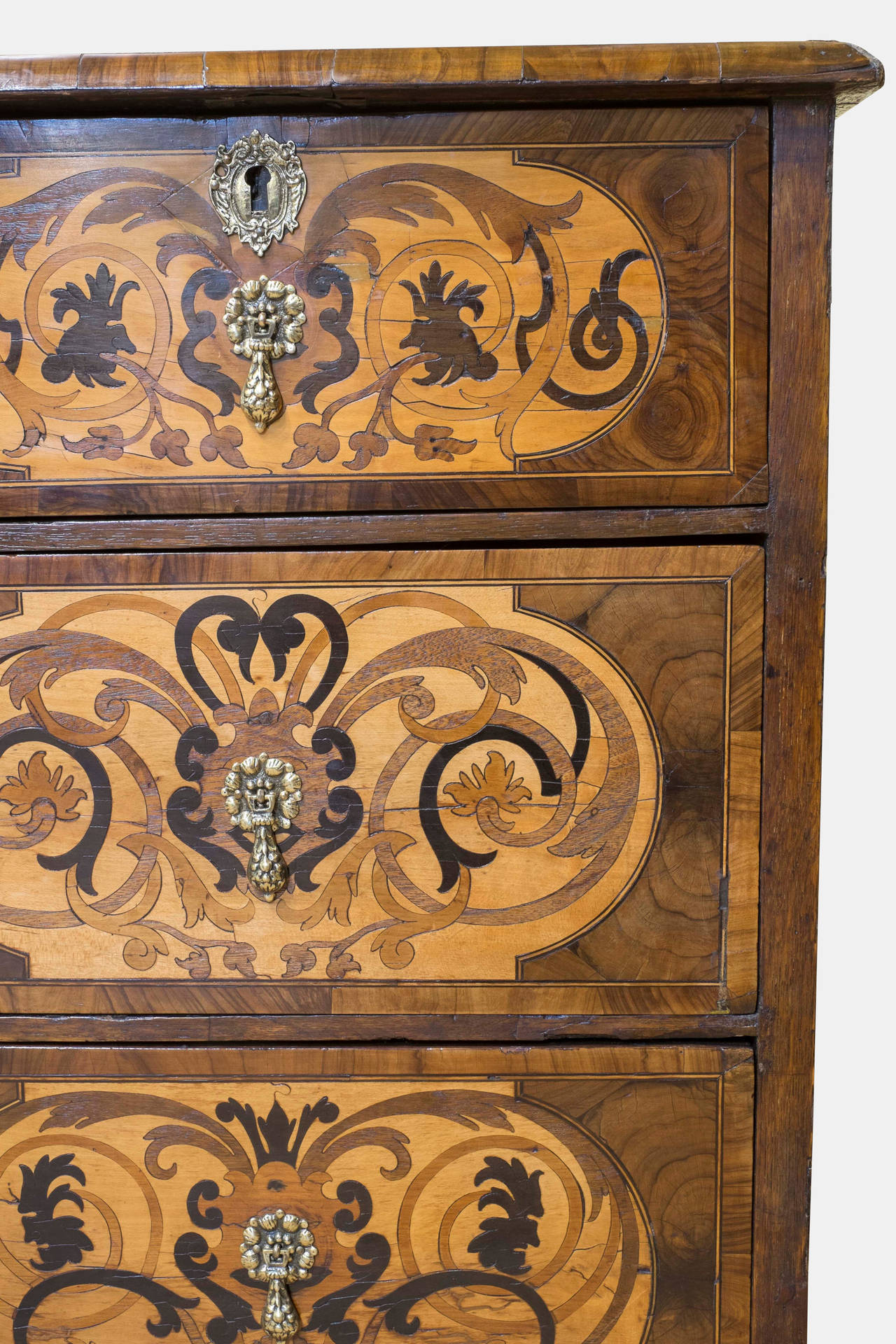 A William & Mary chest of drawers. Inlaid with various woods, including walnut , holly, olivewood oysters on sides, boxwood, ebony, bog oak, cedar and boxwood.
Replaced brasses and bun feet

Circa 1680