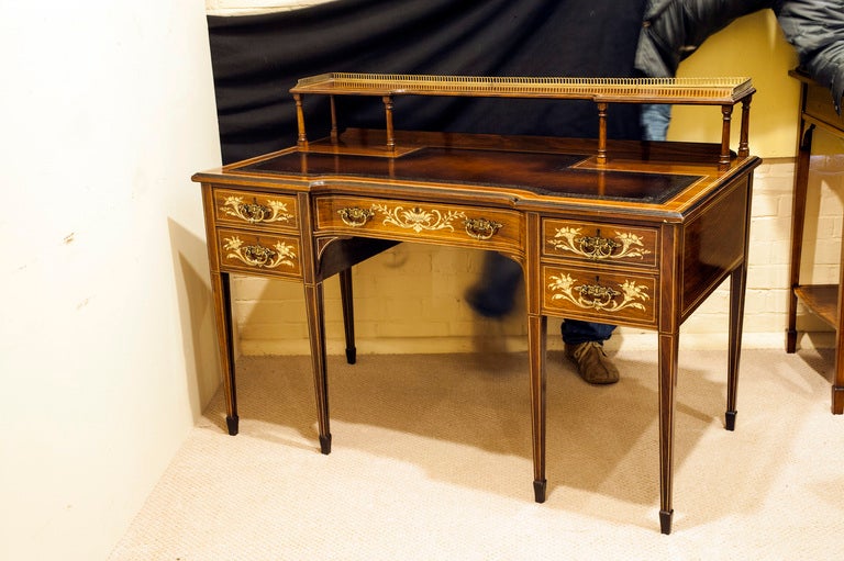 A beautiful Victorian rosewood writing desk with floral inlay, with brass surround to upper shelf and square tapering legs.