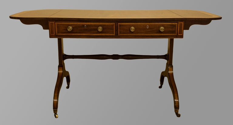 A very fine Sheraton period mahogany sofa table inlaid in harewood and ebony stringing with original gilded handles. Circa 1780