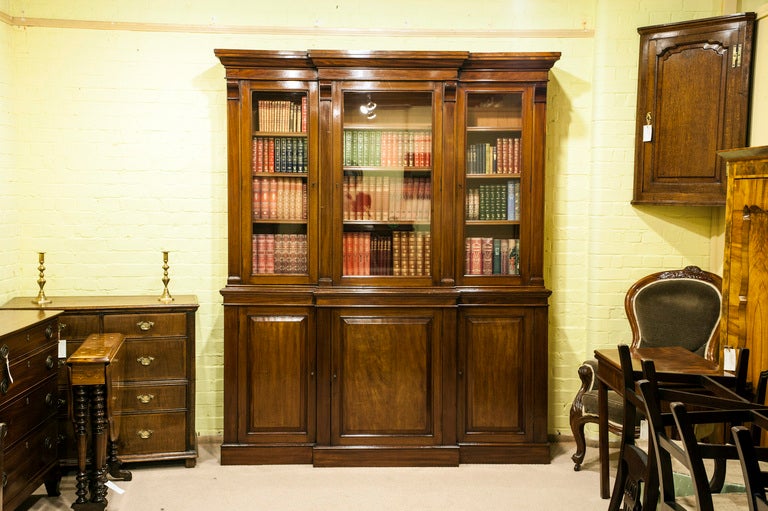 A good Victorian mahogany breakfront bookcase, with three glazed glass doors to the top section and fielded panelled doors to the base. On the back of the base is a brass plaque with the cabinet makers name and address:

Smee and Cobay,
London,