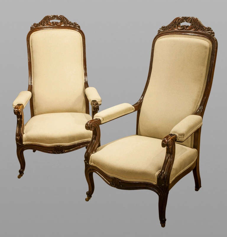 An elegant pair of late 19th Century mahogany continental serpentine fronted open armchairs on cabriole legs with carved tops. Recently reupholstered in a contemporary linen fabric. 