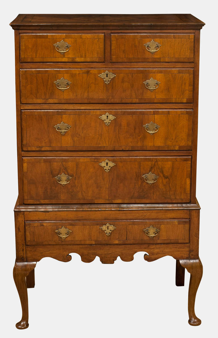A George I walnut chest on stand of rare small size.
With quartered and crossbanded drawers, old but not original brasses.
Raised on front cabriole legs (old replacements)

Circa 1725