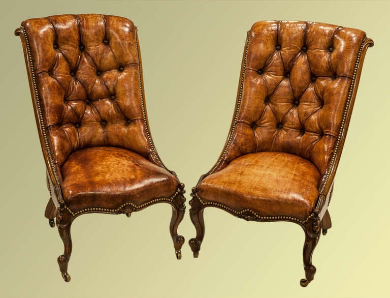 A lovely pair of rosewood drawing room chairs, very crisply carved and upholstered in antique buttoned hide - signed by Flashman of Dover, and dated 1856.