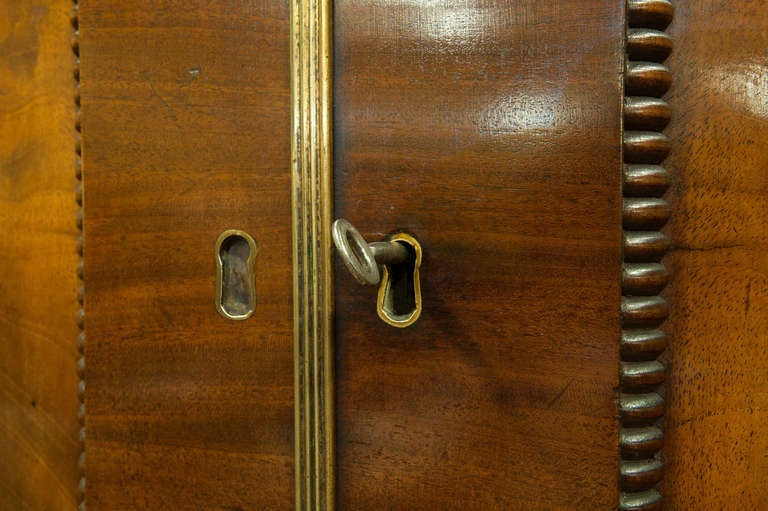 A William IV mahogany linen press of fine colour with arched flame figured doors enclosing slides. 
2 short and 2 long drawers below.
Raised on turned feet.

Circa 1830