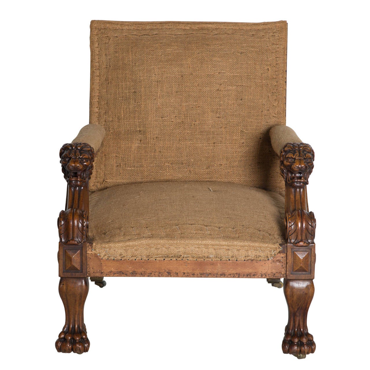 Pair of 19th century mahogany Gainsborough armchairs with carved lions head arms on paw feet, fitted with brass roller castors