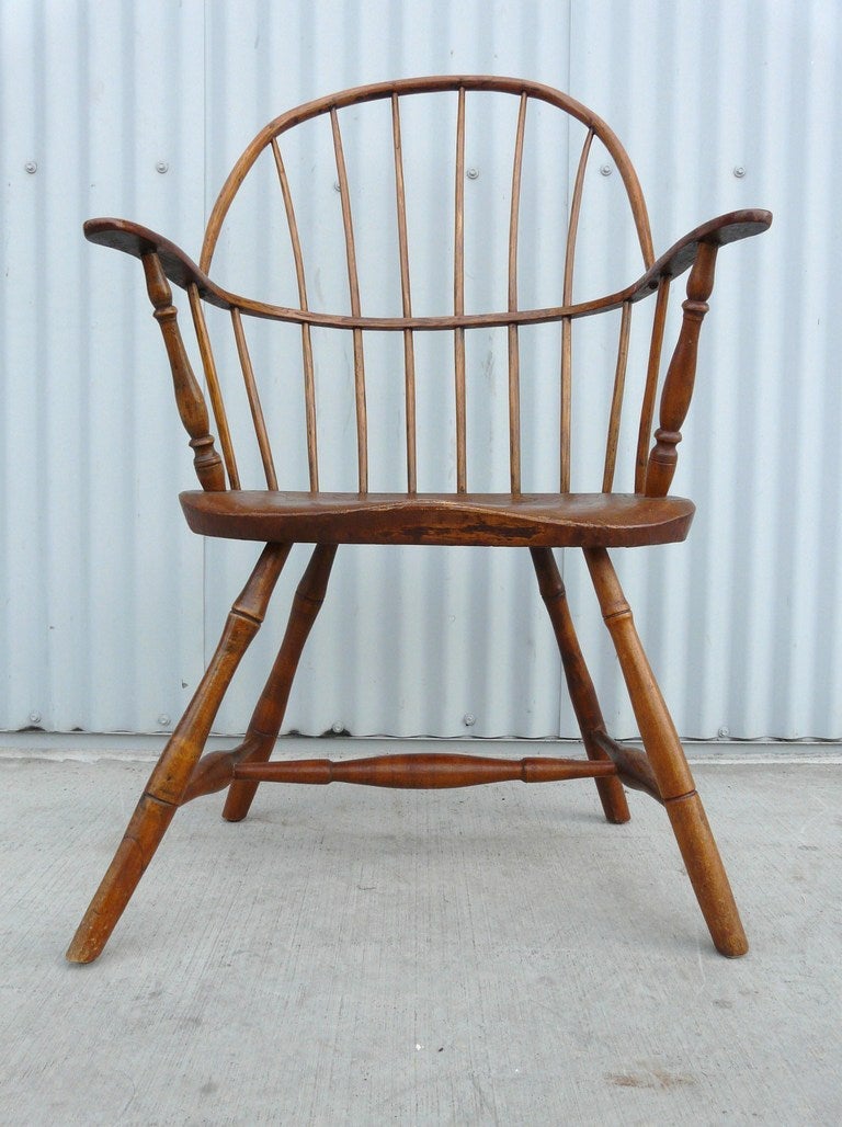 Early Windsor hoop back chair, New England, all hand hewn with peg joints, steam moulded frame, the tapering bow with sloping arch above arm rail with handholds pierced by 10 spindles,  arms supported by hand turned posts, thick plank saddle seat