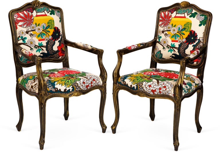 Traditional French chairs whimsically upholstered in Schumacher’s bold-hued Chaing Mai Dragon.