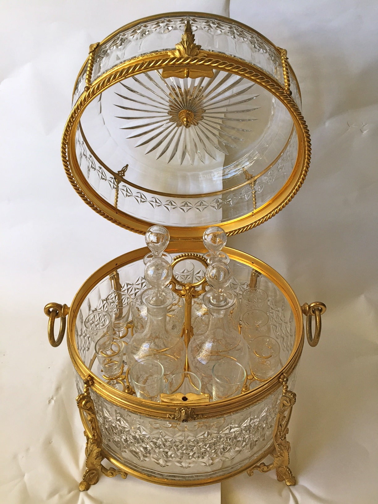 This is a beautiful Tantalus gilt bronze and crystal in excellent condition the crystal cut and mounted in finley cast gilt bronze. The glassware complete
and in excellent condition as well. 16 glasses four bottles and the gilt mounted
box.