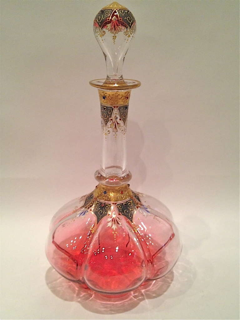 A fabulous example of the work of the Moser Glass, this decanter
is Blown Out using a frame to archive the shape seen here. Then
It was gilded with gold by a Firing process, also having little glass
beading applied. Also the glass has been faded