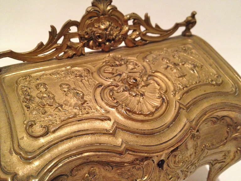 This Commode Form Jewelry Box is unique and rare, the detail are nicely cast and the subject matter is appealing, with putti and 
Courtship scenes decorating. It has a been around a long time feel
To it with the gilding slightly rubbed in the high