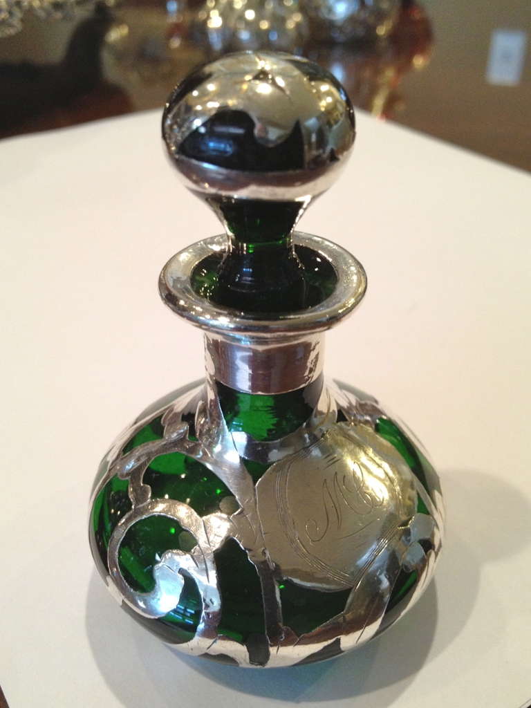 A charing perfume in emerald green glass in a lovely art nouveau
Shape with beautiful silver work.