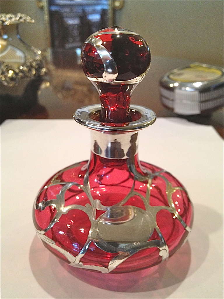 Very nice example of silver overlay in the desirable cranberry
Color. How beautiful this will look on the dressing table or anywhere else.