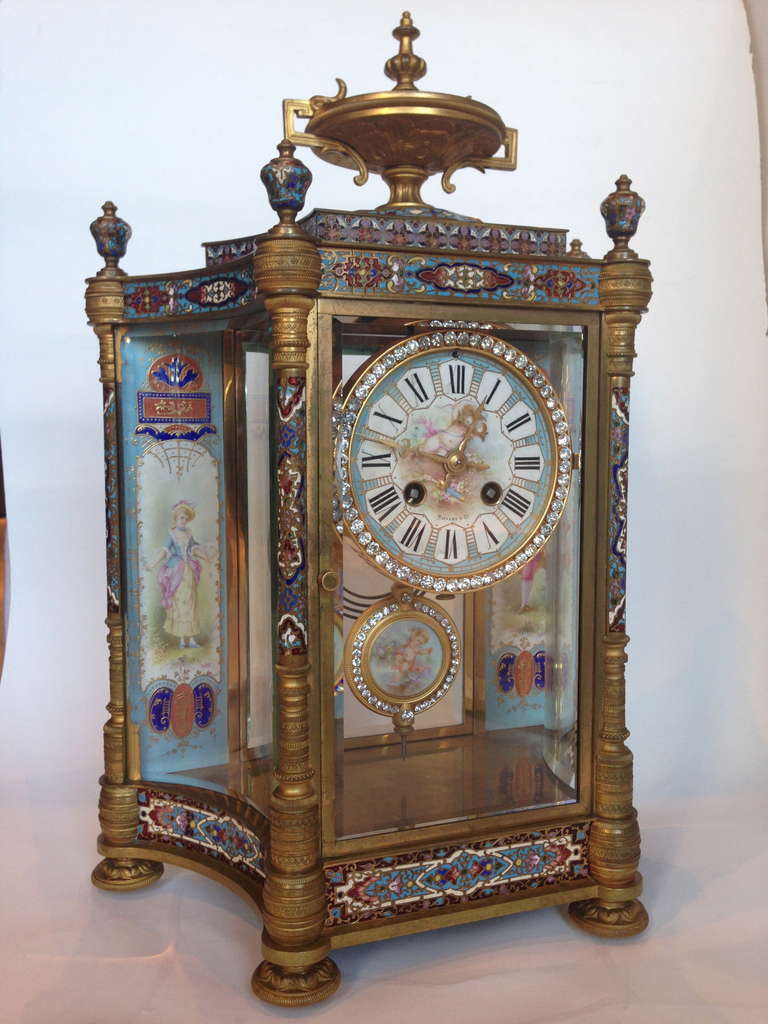 This is a rare model we have not seen before, retailed by the world famous firm
Tiffany and Co. New York. The gilt bronze clad with exceptional quality Champleve enameling, and mounted with fine porcelain panels painted with
figures dressed in