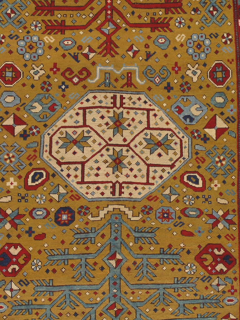 The Yellow field scattered with minor stylized flower heads, hooked panels and minute cross-motifs around a column of ivory octagonal panels containing radiating flower heads and minute cross-motifs flanked on either side by ivory and blue angular