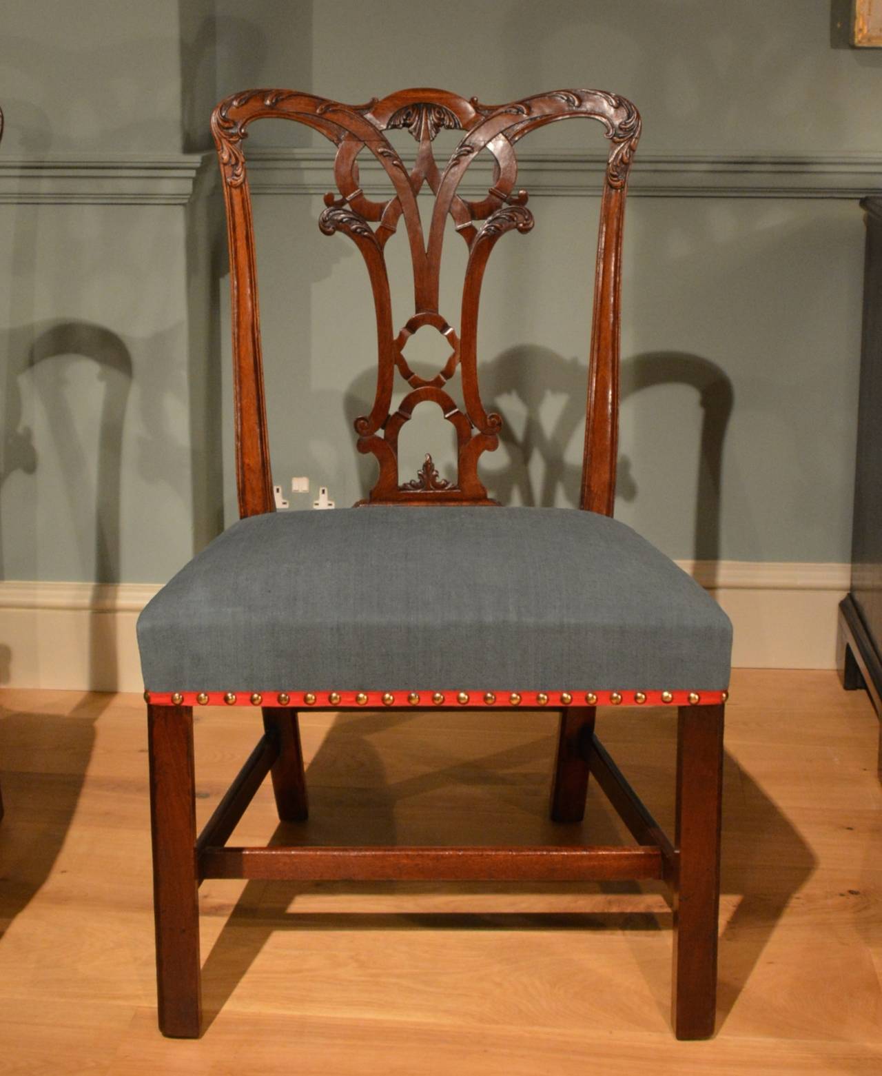 A fine set of ten Chippendale period mahogany dining chairs with well carved backs having interlaced splats, with stuff over seats standing on square legs with stretchers, English, circa 1760.