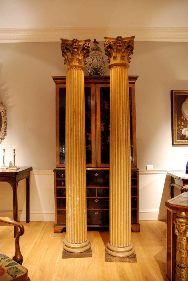A pair of dramatic classical carved giltwood fluted columns with corinthian capitals. Circa 1700.