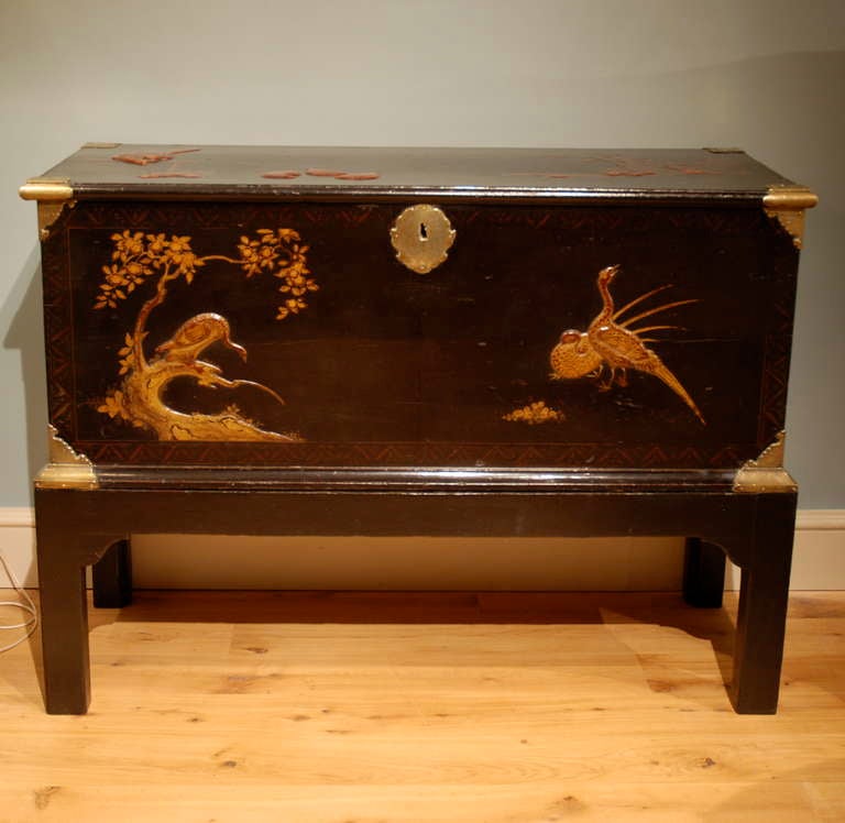 A late 17th century Japanese lacquer trunk with sparse stylised decoration standing on its ebonized English mid 18th Century stand. 
Circa 1730.