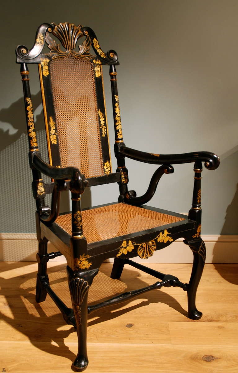 A rare set of six armchairs, Japanned in black with gilt decorations, having caned panels to the backs and seats, with shell motifs to the cresting rail, the front seat rail and the knees of the cabriole legs.