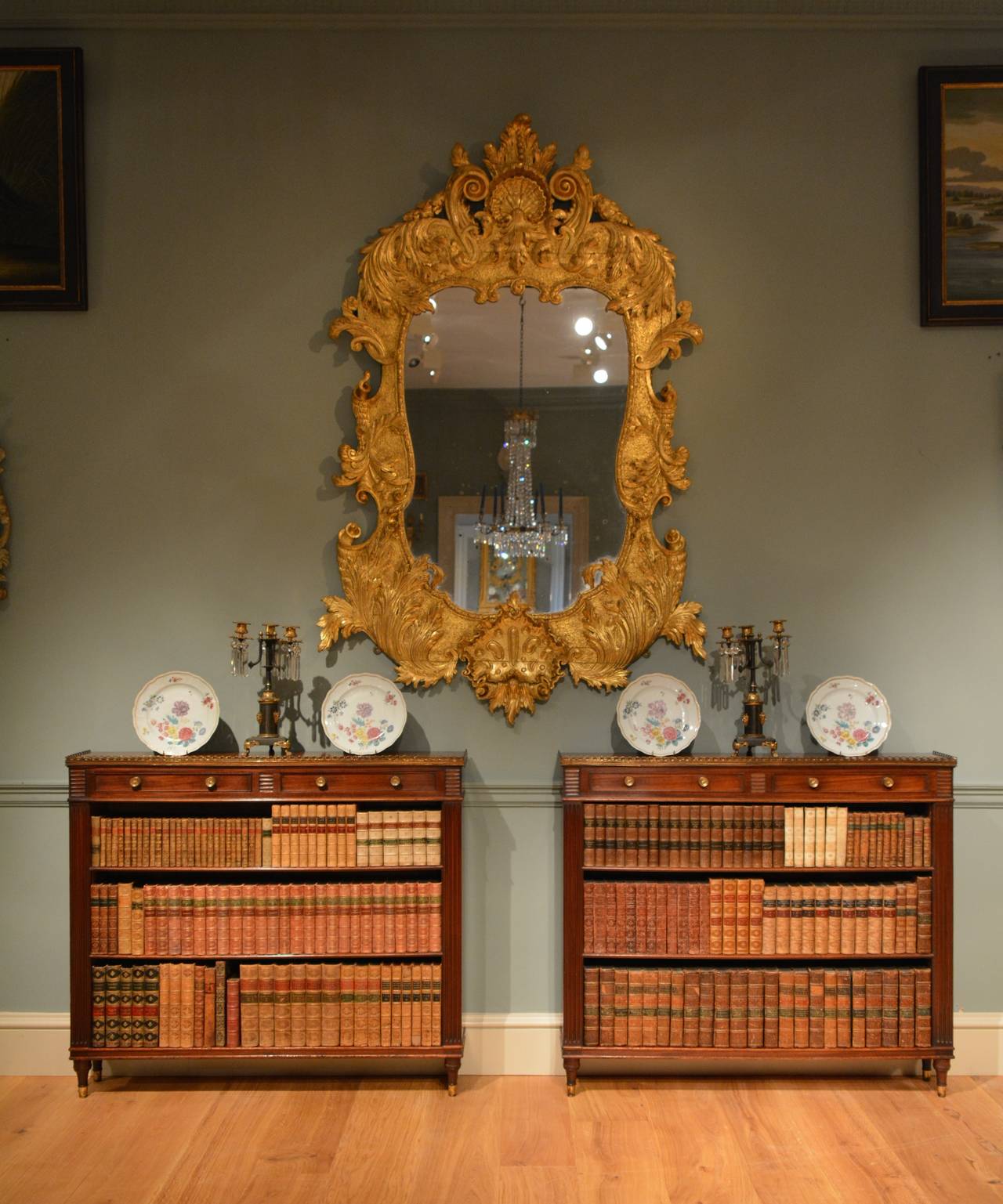 A fine pair of early 19th Century low mahogany bookshelves or display shelves, having lacquered brass gallery, handles and toupie feet, the galleried top over two shallow drawers below which are three shelves, standing on finely turned feet.