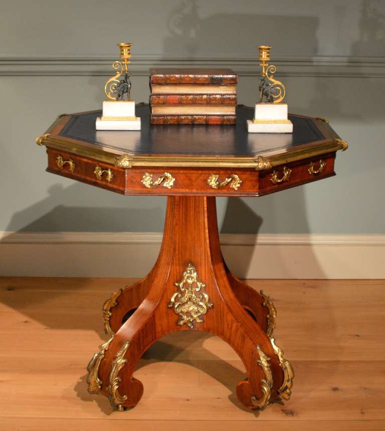 An octagonal ormolu-mounted leather topped kingwood library table. After a design by Bridgens. The top with eight dummy drawers, circa 1830.