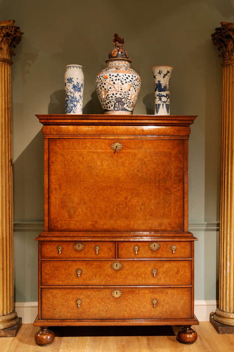 A very fine early 18th Century escritoire veneered in burr walnut, the whole decorated with herringbone and standard cross banding, the fall opening to reveal a finely fitted interior of pigeonholes with oak cased lead paperweights behind which are