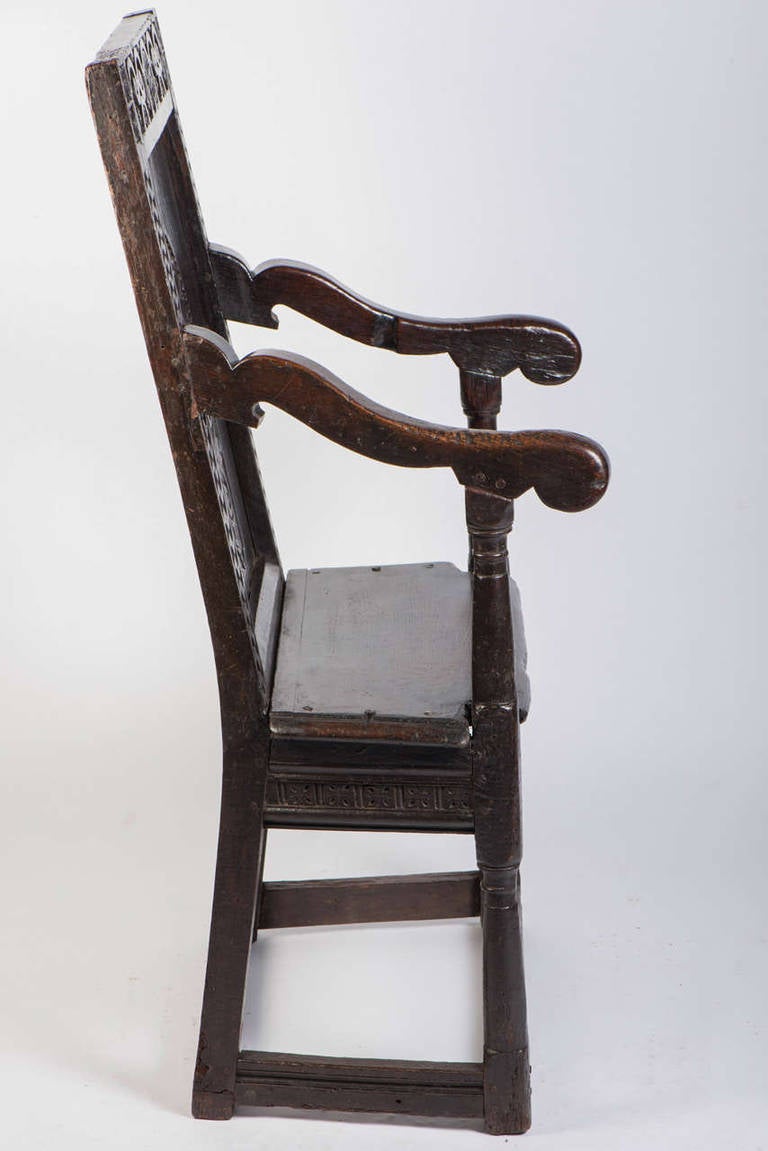 Good oak armchair with carved back and of good colour and patination, 16th century.