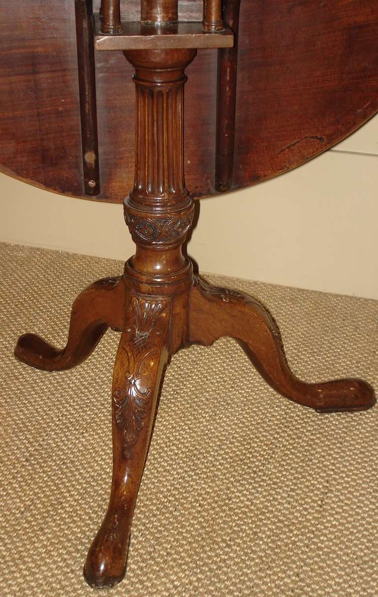 George II period mahogany tilt top table. The fluted column supports a sold top with bird cage action, with carved splay legs terminating in pad feet.

Circa 1750