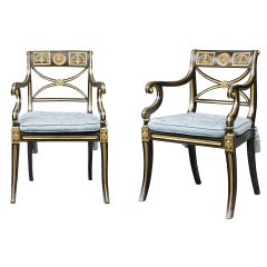 Antique A pair of Regency ebonised and parcel-gilt open arm chairs