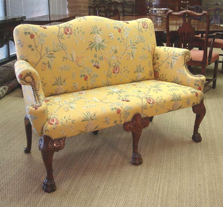 George II period walnut cabriole settee. The cabriole front legs with carved shell motif and gaitered legs terminating in hairy paw feet. The outswept arms beneath an undulating top rail. Now upholstered in Colony 'La Perouse' lampas.

Circa 1740