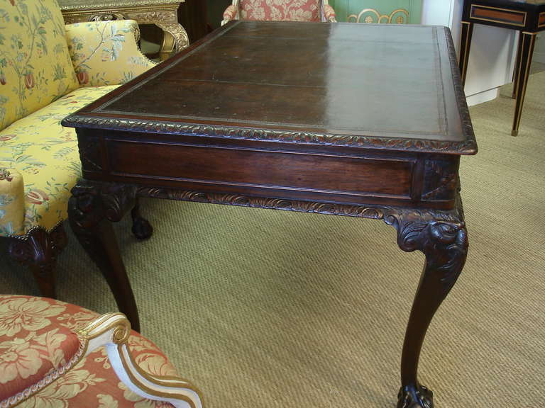 Irish George II style partner's writing table in mahogany. The well-carved cabriole legs with 'green man' motif at the corners and terminating in ball and claw feet. The inlaid leather writing surface surmounts a writing surface with two drawers