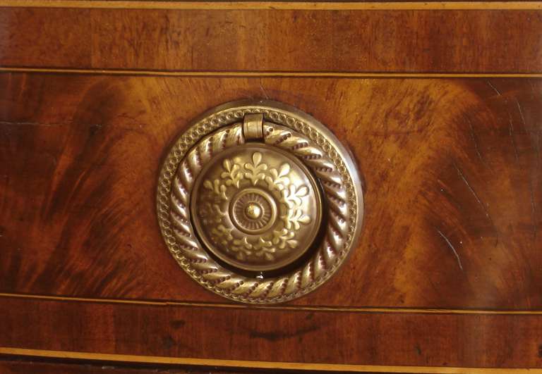 George III period mahogany and strung demilune sideboard of large size. The well-figured drawer fronts surrounded by boxwood stringing, with the well-figured top fronted by checkered banding, which banding outlines the bottom perimeter. 

Circa