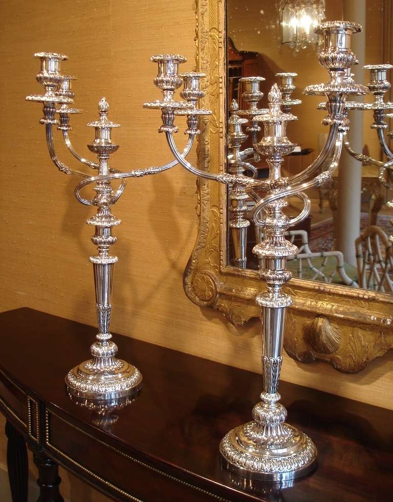 A pair of late George III/Regency period by Matthew Boulton. Of silver Sheffield old plate, the bases of an inverted cone shape, with gadrooned motif. The candle branches detachable with detachable drip pans. The centre candleholder with cover to
