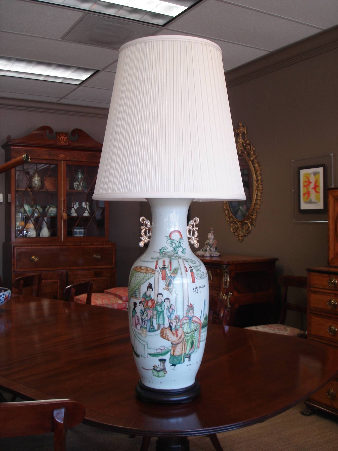 Chinese enameled porcelain baluster vase, with waisted neck supporting gilt porcelain handles formed as stylized temple dogs, over an ovoid body. Now drilled and mounted as a table lamp. The front with scholars in courtly pursuits, the reverse with