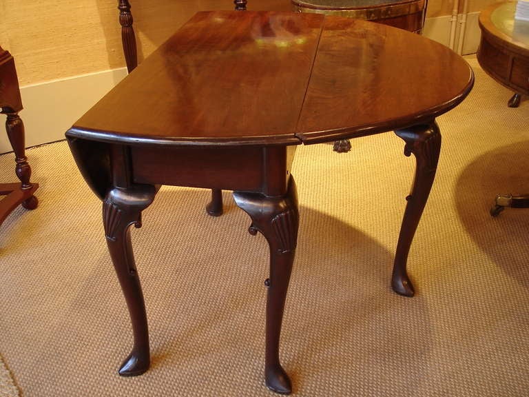 A George II period mahogany drop leaf table of small size. The slightly oval drop leaf top over cabriole legs with shell carving and 'C' scrolls, and pointed pad feet, of beautiful color and figure.

Circa 1750